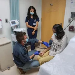 Medical students meet with a patient