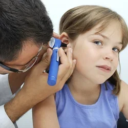 Otolaryngologist making a revision to a girl with an otoscope. 