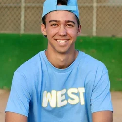 A young black man in casual sports attire smiling at the camera.
