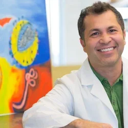 physician in lab coat sitting in office