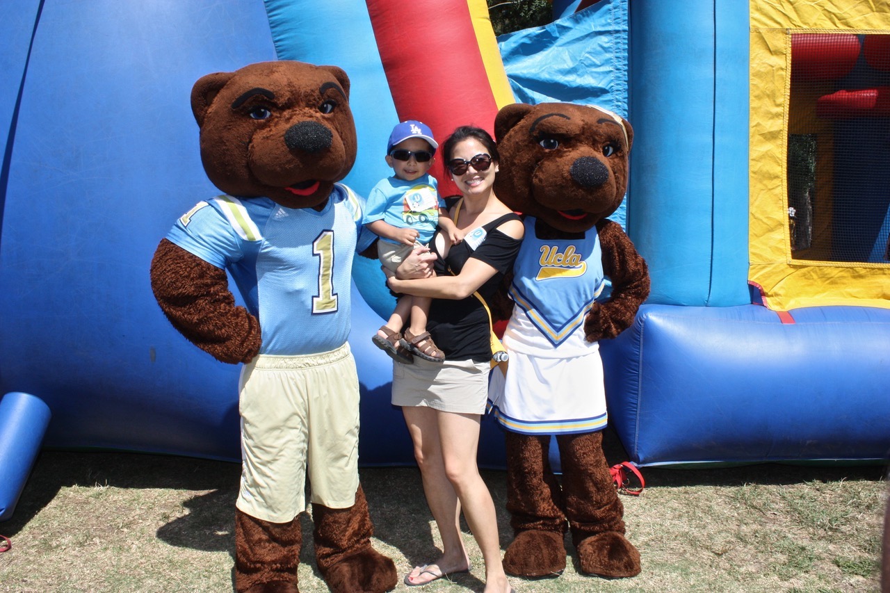 Dr. Justine Lee a cleft lip and palate specialist, pictured with a child and UCLA mascots