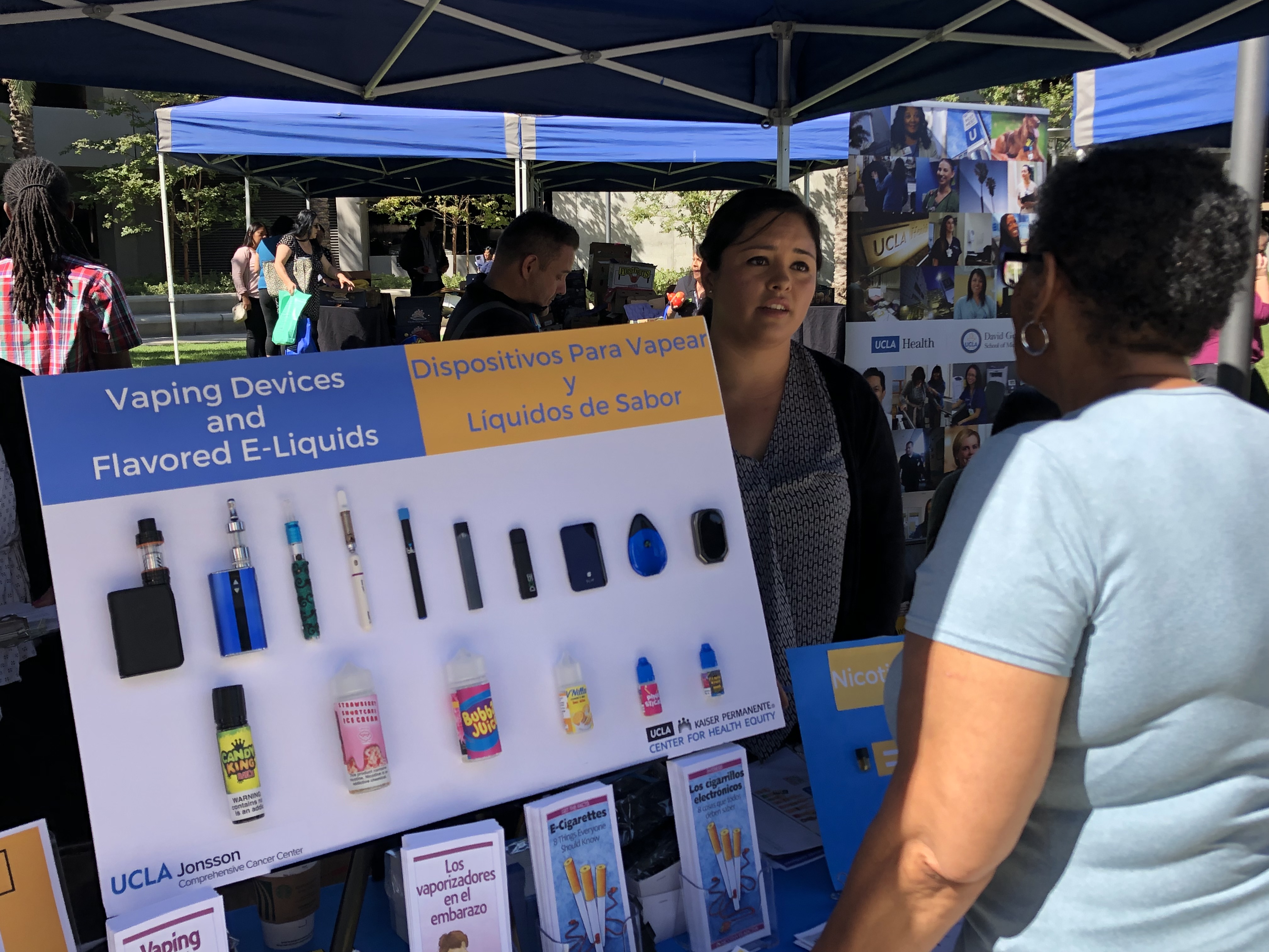 How to Prevent Cancer Via Lifestyle Choices. People review information on vaping at a health fair