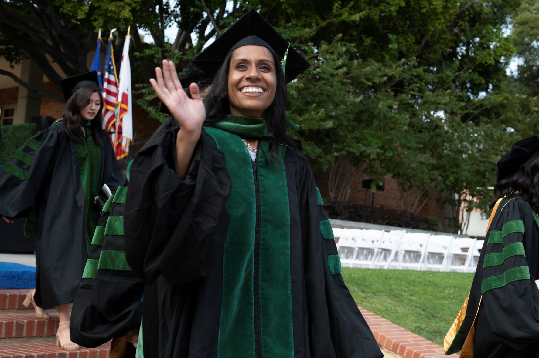 Medical school graduate waving at commencement