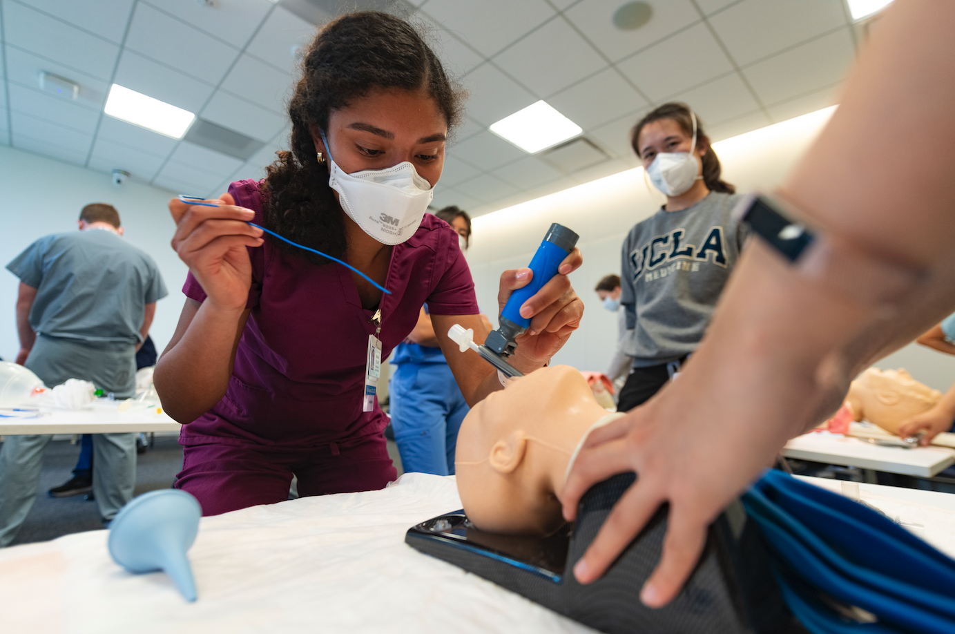 A medical student places a tracheostomy tube during a simulation session.