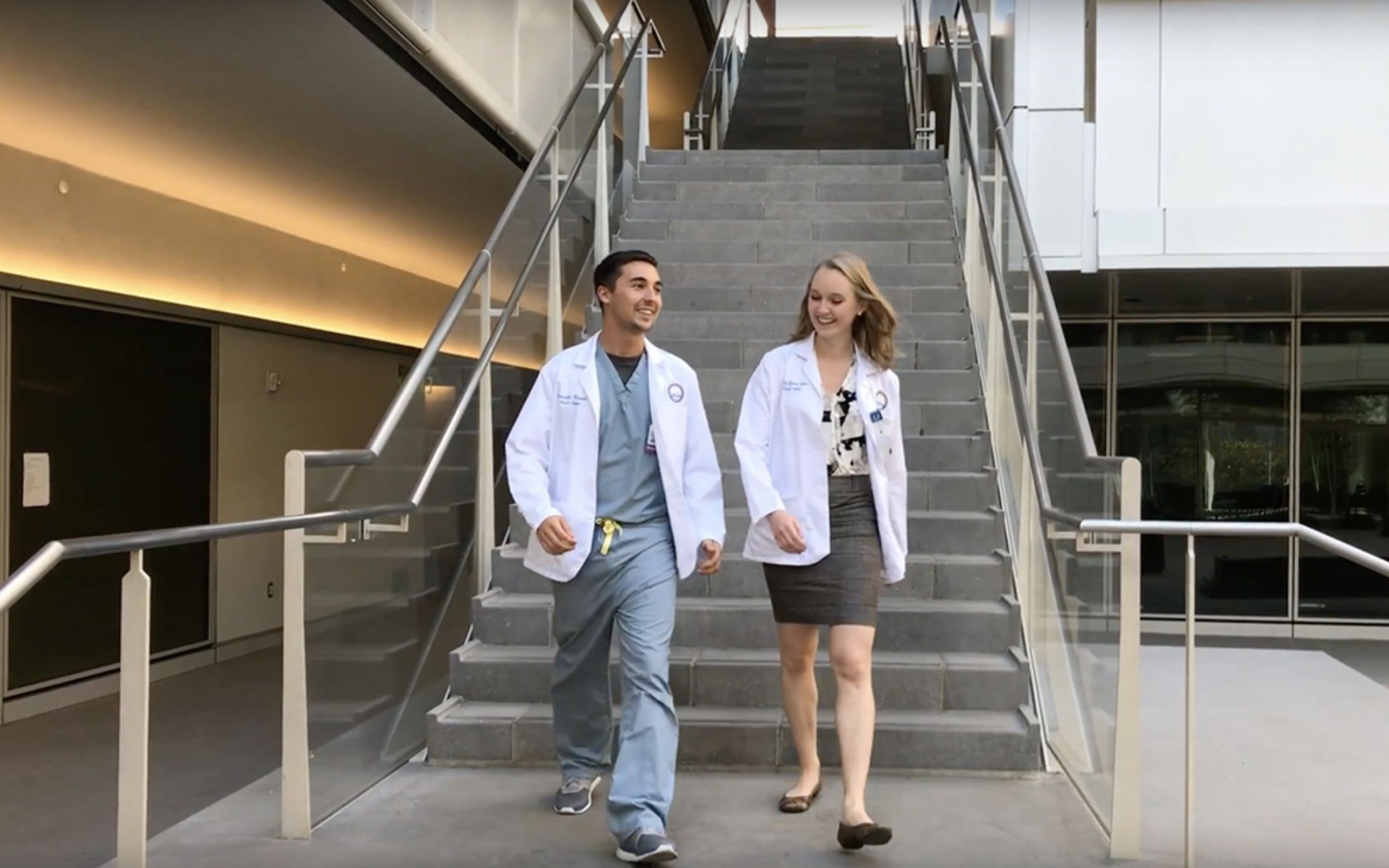 Two medical school students walking down the stairs of the Geffen Hall courtyard