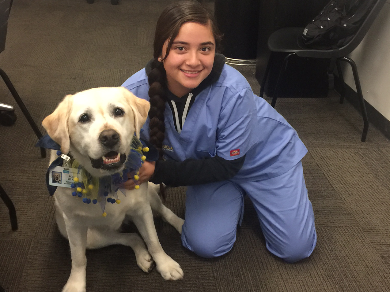 Student from Turner-UCLA Allied Health Internship pictured with a People Animal Connection visitor