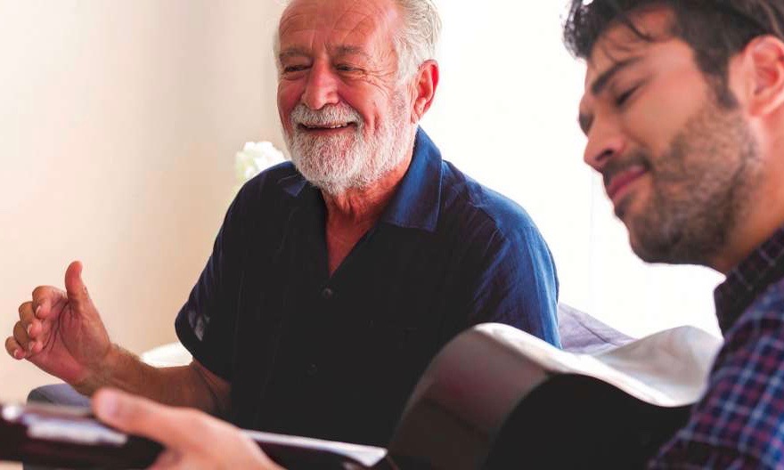 What Is Alzheimer's Senior Male Patient Enjoys Listening to Younger Male Companion Playing Guitar