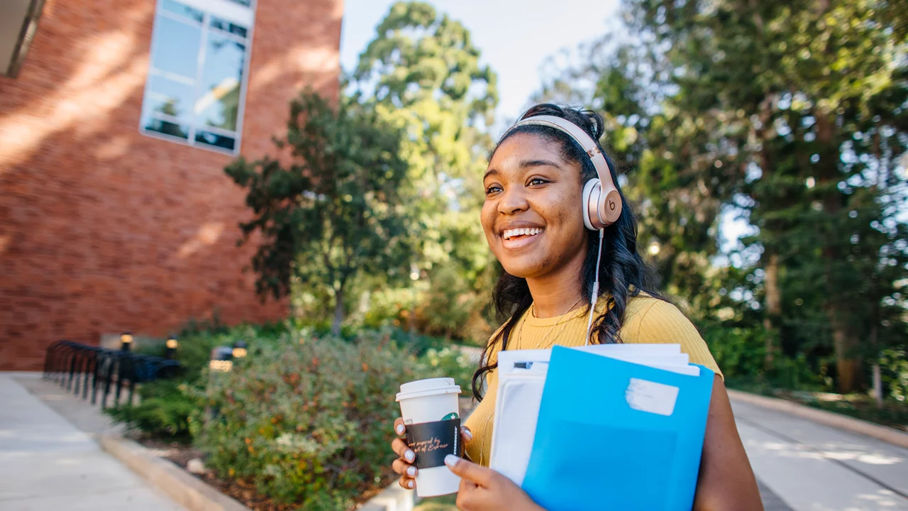 Medical student standing in front of Geffen Hall and the botanical gardens