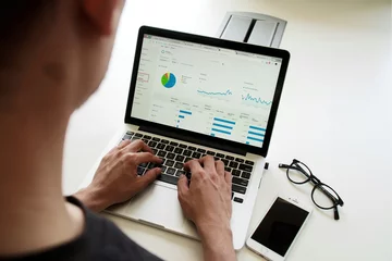 Person looking at statistical chart via laptop