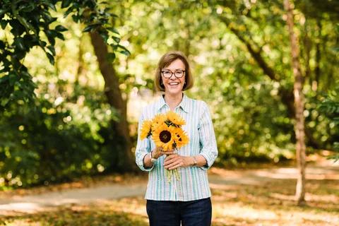 Care Cure Prevent Kensington Senior Living Senior Holding Sunflowers in Nature