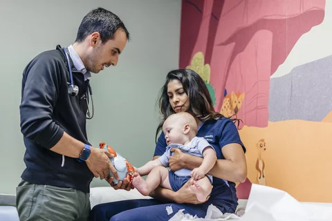 3 Challenges Pediatricians Face Doctor with Infant Patient and Mother