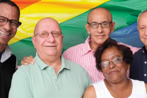 Group of people in front of rainbow flag