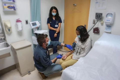 Medical students meet with a patient