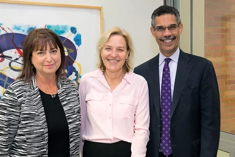 two female and male professionals standing