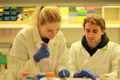 Two researchers in lab coats conducting research
