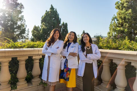 Medical student Clara Đỗ Trần Nguyễn, pictured in her white coat along with her two physician sisters, shares her story of becoming a doctor