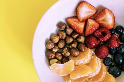 strawberries oranges and nuts on a plate