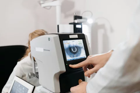 a doctor looking at the image of someone's eye on a screen