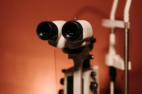 image of a white slit lamp on a table with an orange wall in the background