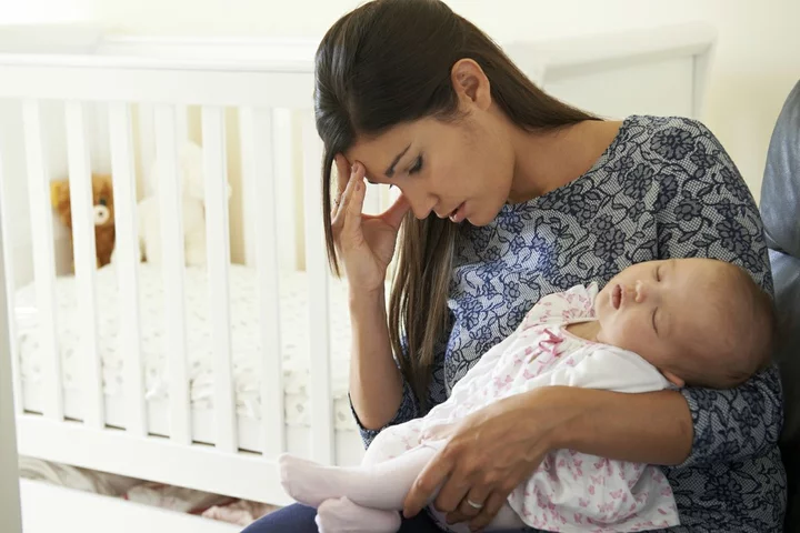 Mother struggling holding newborn baby depicting the common breastfeeding challenge of mastitis