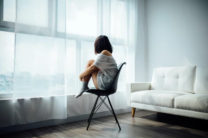 A person sitting in a protective position