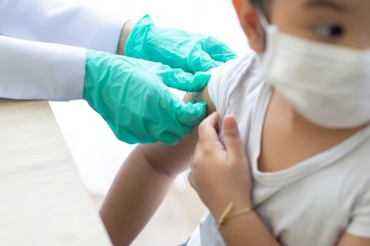 Hepatitis B Vaccine Gloved Adult Hands Preparing a Child Patient for Shot in the Arm
