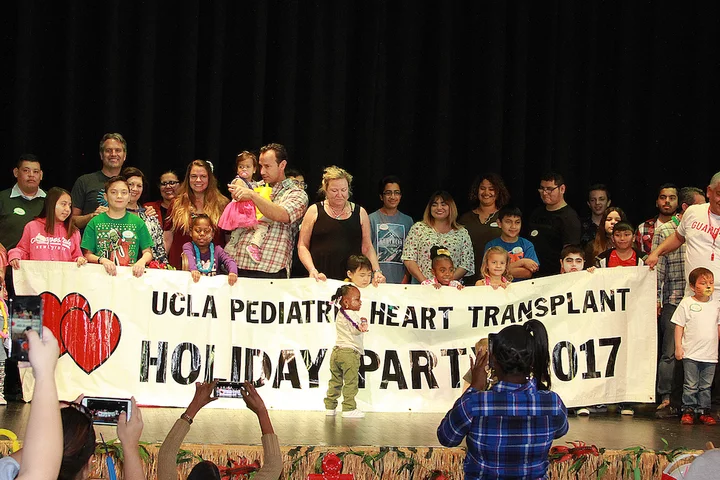 A team of pediatric cardiology physicians hosting a party for pediatric transplant patients