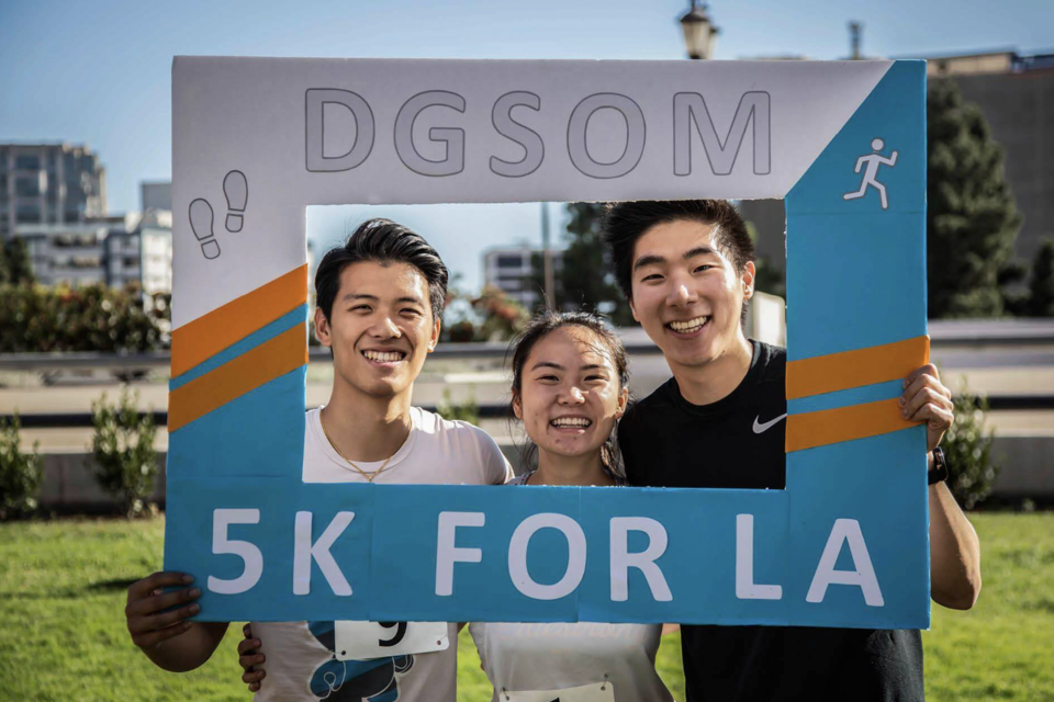 Medical school students with a sign for the 5k for LA put on by students in the medical school.