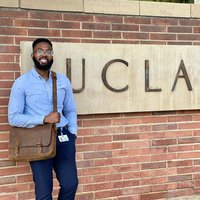 Dr. Igwe standing in front of a UCLA sign on campus