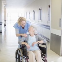 Occupational or Physical Therapist Assisting Elderly Woman in Wheelchair