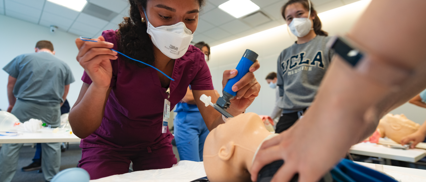 A medical student places a tracheostomy tube during a simulation session.
