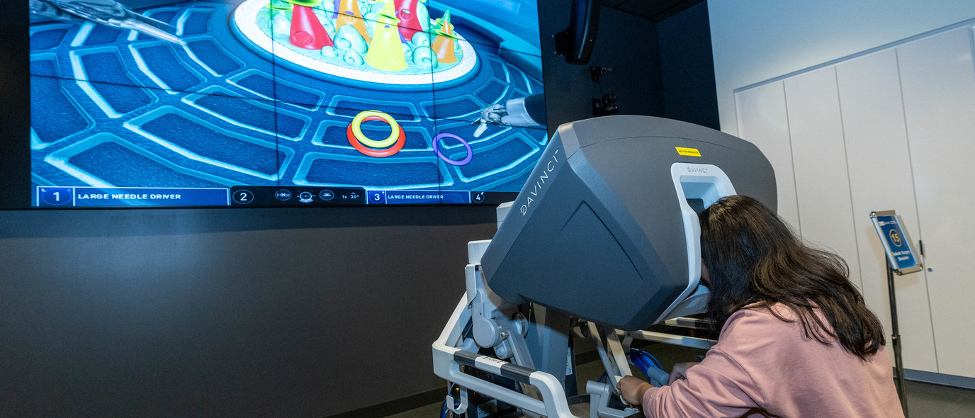 Guest uses robotic surgery simulator at Rosenfeld Hall opening event. The system is compatible with platforms used in operating rooms at Ronald Reagan UCLA Medical Center.
