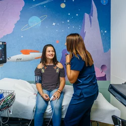 A pre-teen girl with a UCLA Health nurse being prepped for a procudure