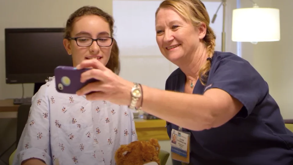 Social media in the clinical setting. A care giver with a patient, taking a selfie