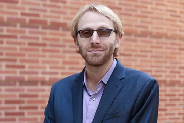 Dino Di Carlo standing in front of a brick wall