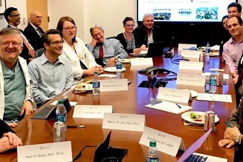 A group of people sitting at a conference table 