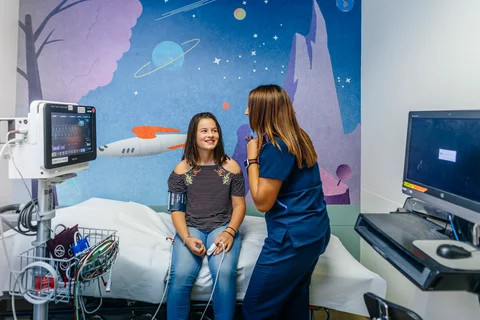 A pre-teen girl with a UCLA Health nurse being prepped for a procudure