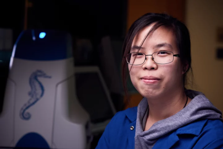 A lab member in the Metabolism Research Theme, smiles for the camera