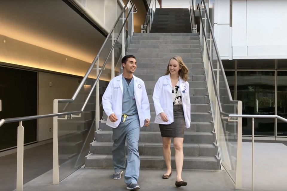 Two medical school students walking down the stairs of the Geffen Hall courtyard